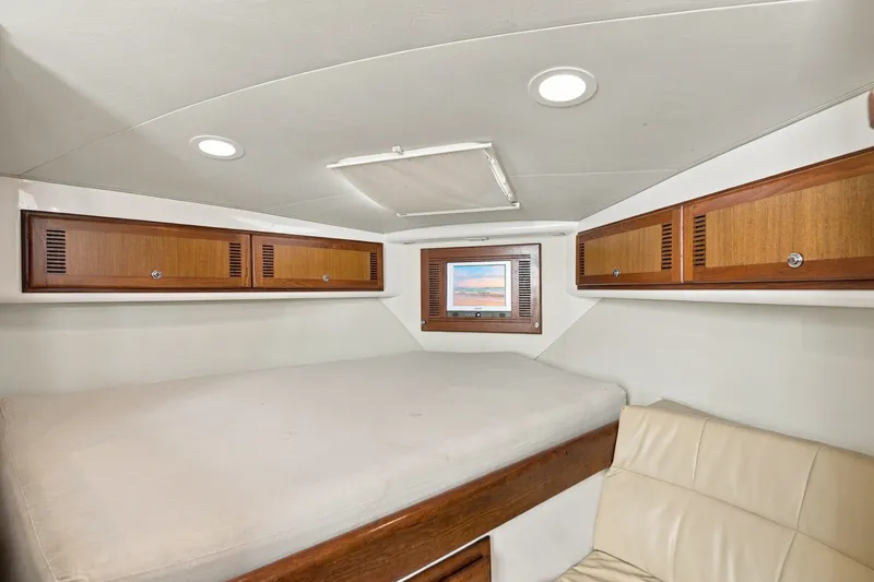 Slide: The Image of Interior cabin of 2005 Cabo 35 Express boat with wooden cabinets and cozy bed. - 23