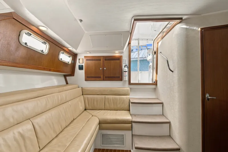 Slide: The Image of Interior of 2005 Cabo 35 Express yacht with beige seating and wooden accents. - 24