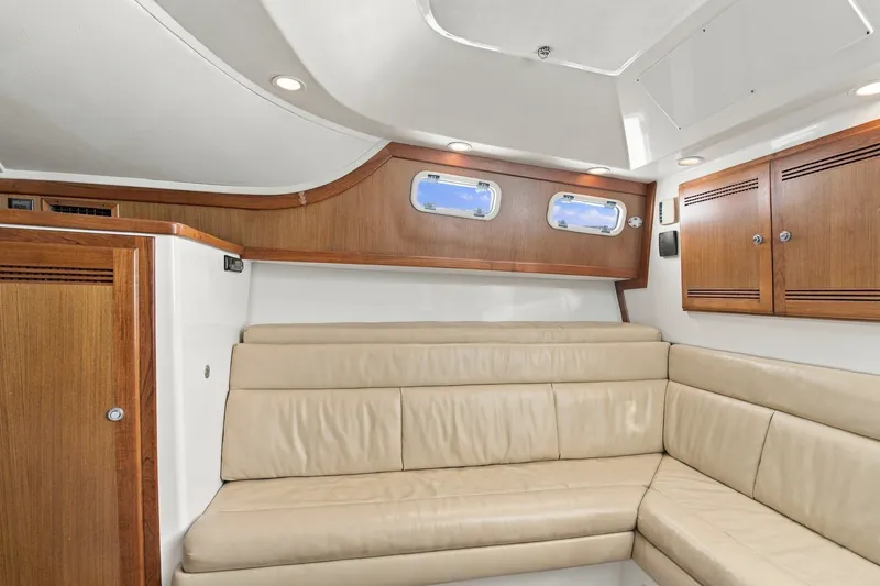 Slide: The Image of Interior of 2005 Cabo 35 Express yacht with beige leather seating and wooden cabinets. - 25