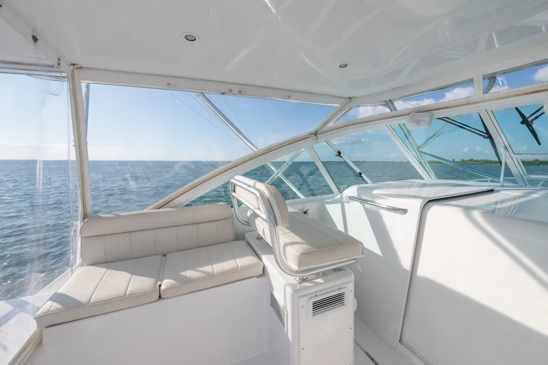 Slide: The Image of 2005 Cabo 35 Express yacht interior with ocean view, featuring white seating and clear windows. - 6