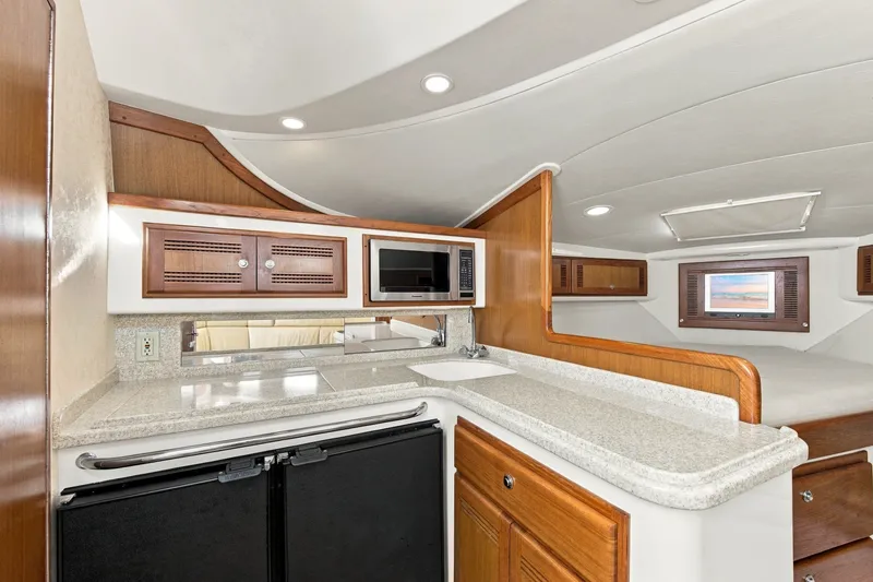 Slide: The Image of Luxurious 2005 Cabo 35 Express yacht interior with modern kitchen and cozy sleeping area. - 21
