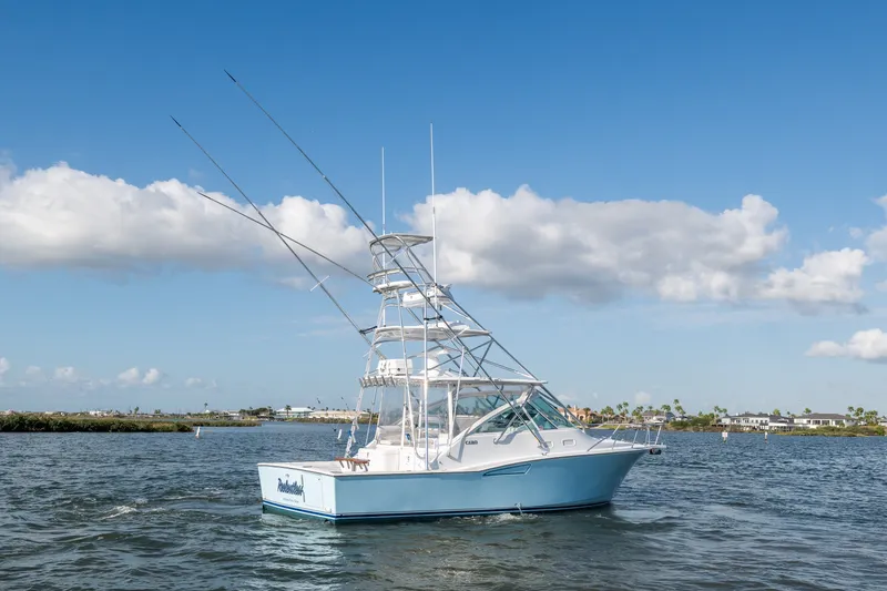 Slide: The Image of 2005 Cabo 35 Express boat on water under blue sky with clouds. - 2