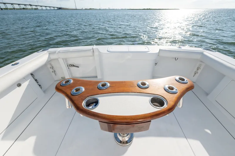 Slide: The Image of Cockpit of 2005 Cabo 35 Express boat with wooden rod holders, overlooking water. - 10