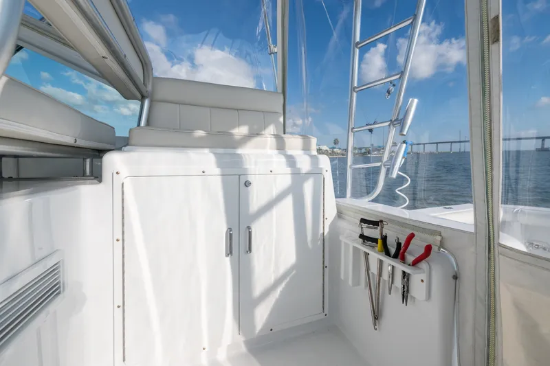Slide: The Image of 2005 Cabo 35 Express boat interior with tools and ocean view. - 9