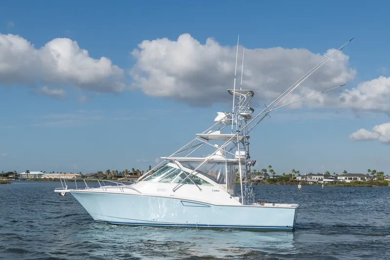 The Image of 2005 Cabo 35 Express boat on calm water under blue sky with clouds. - 0