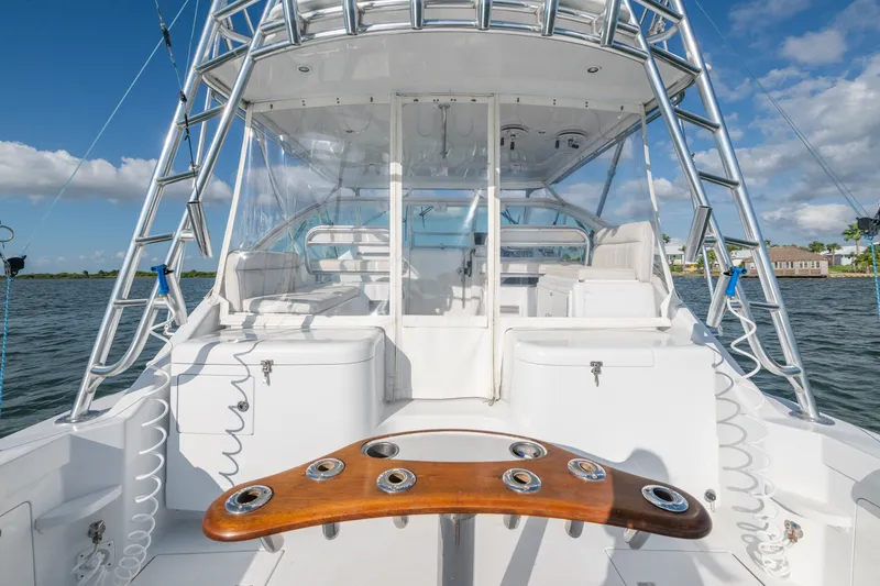 Slide: The Image of 2005 Cabo 35 Express yacht interior with fishing rod holders, ladder, and seating. - 11