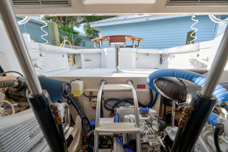 Slide: The Image of Engine compartment of a 2005 Cabo 35 Express boat, showcasing mechanical components and deck area. - 35