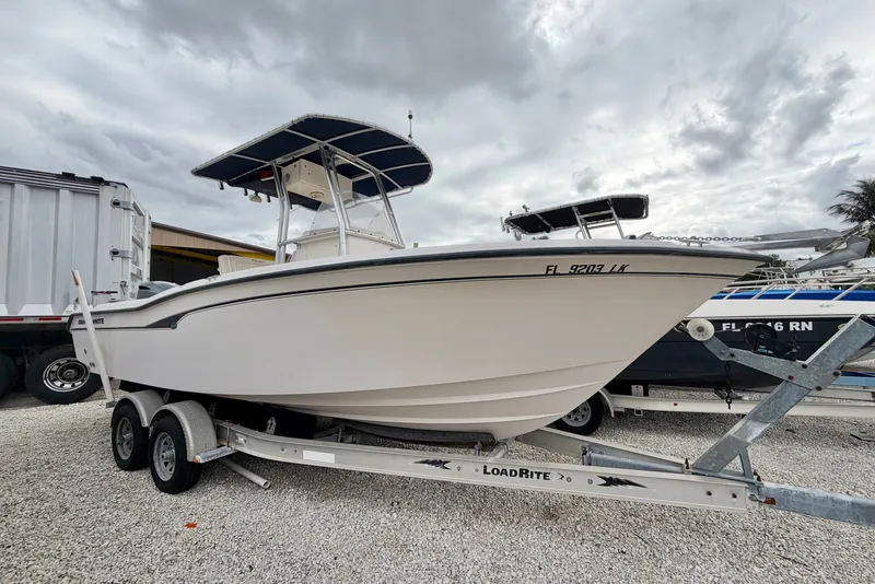 The Image of 2001 Grady-White Advance 247 boat on LoadRite trailer, parked outdoors under cloudy sky. - 0