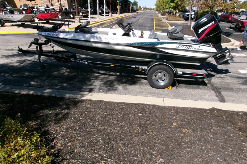 Slide: The Image of 2002 Triton Tr-175 SC boat on trailer, parked outdoors with Mercury engine. - 3