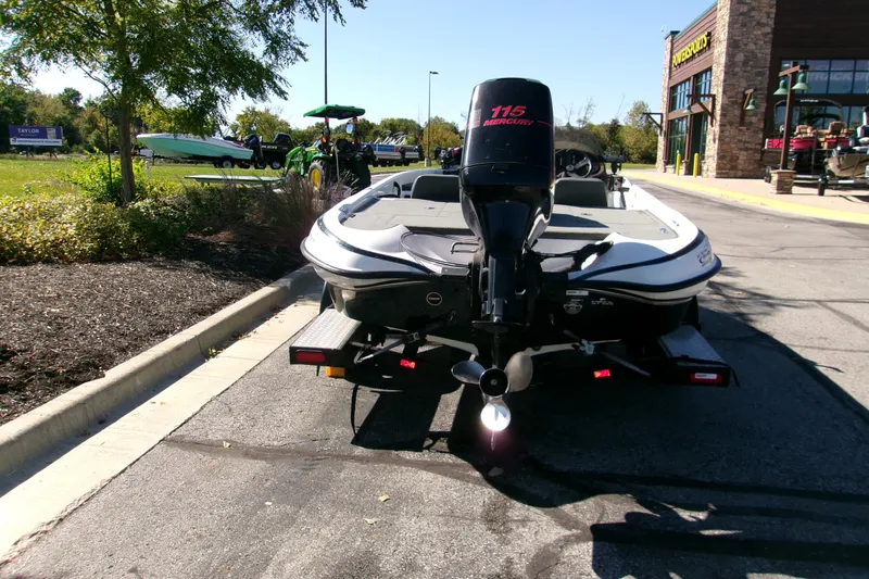 Slide: The Image of 2002 Triton Tr-175 SC boat with Mercury 115 engine parked outside a store. - 2