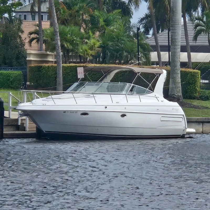 The Image of 2000 CUISERS Cruisers 3575 Express yacht docked by palm trees. - 0