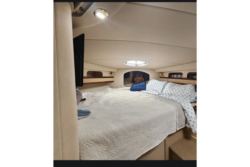 Slide: The Image of Interior cabin of 2000 Cruisers 3575 Express yacht with cozy bedding and porthole. - 11