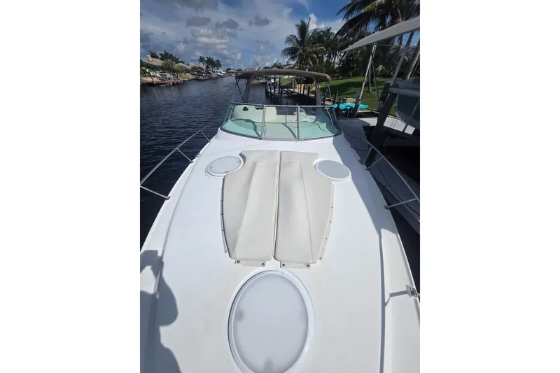Slide: The Image of 2000 CUISERS Cruisers 3575 Express yacht on a sunny day, docked by palm trees. - 2