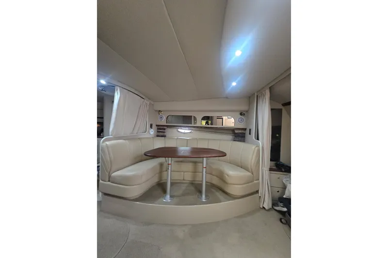 Slide: The Image of Interior of 2000 Cruisers 3575 Express yacht with beige seating and wooden table. - 9