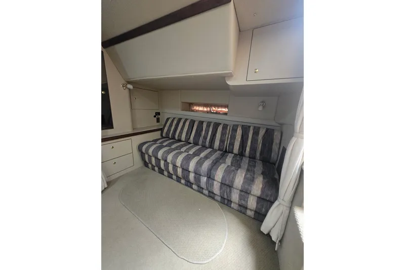Slide: The Image of Interior of 2000 Cruisers 3575 Express yacht with striped sofa and storage cabinets. - 12