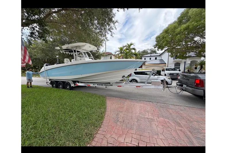 The Image of 2008 Boston Whaler 320 Outrage on trailer, parked in residential area with lush greenery. - 0