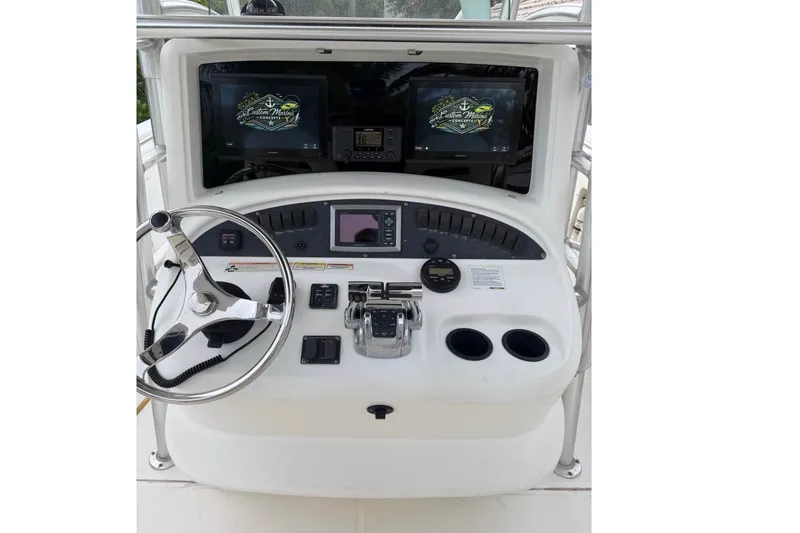 Slide: The Image of 2008 Boston Whaler 320 Outrage helm with steering wheel, controls, and navigation screens. - 1