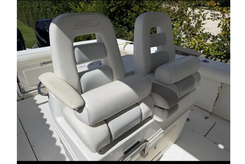 Slide: The Image of 2008 Boston Whaler 320 Outrage boat seats, featuring cushioned armrests and backrests. - 2