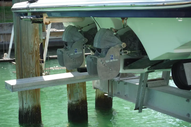 Slide: The Image of 2011 Yamaha Boats 242 Limited on lift, showcasing dual jet drives in clear water. - 45