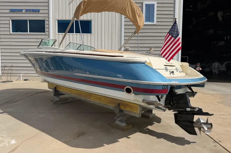 Slide: The Image of 2001 Chris-Craft Launch 28 boat with American flag, docked near a ship store. - 6