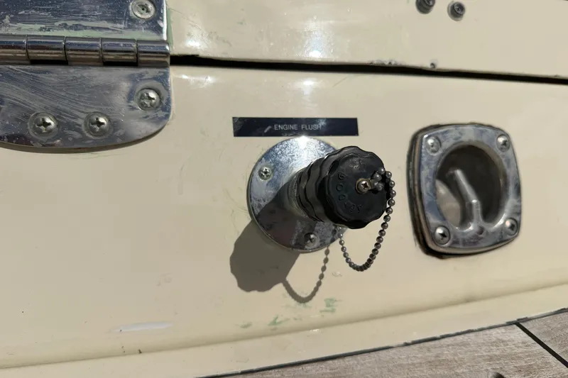 Slide: The Image of Close-up of a 2001 Chris-Craft Launch 28 engine flush port with metal fittings. - 29