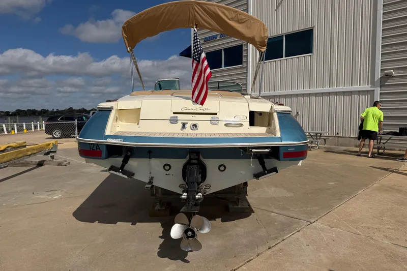 Slide: The Image of 2001 Chris-Craft Launch 28 boat with American flag, docked near a building. - 7