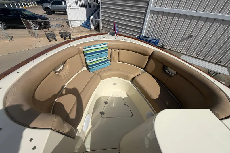 Slide: The Image of 2001 Chris-Craft Launch 28 boat with tan seating and striped cushion in a marina setting. - 17