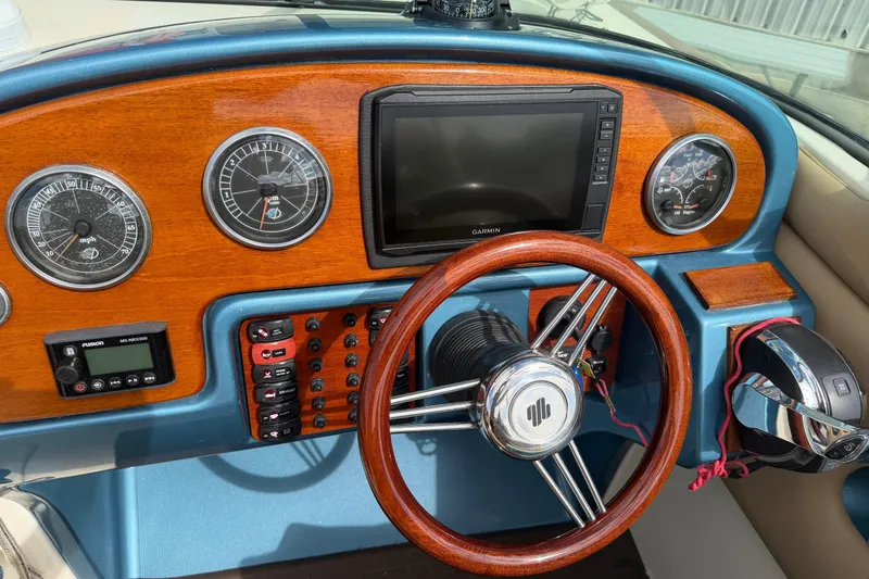 Slide: The Image of Dashboard of a 2001 Chris-Craft Launch 28 boat with wooden accents and modern controls. - 13