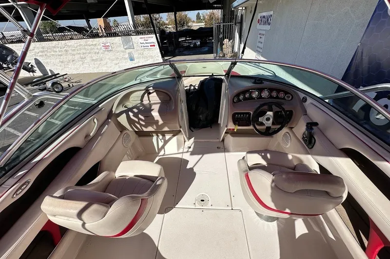 Slide: The Image of Interior of a 2000 Chaparral 216 SSi boat with beige seating and dashboard controls. - 11