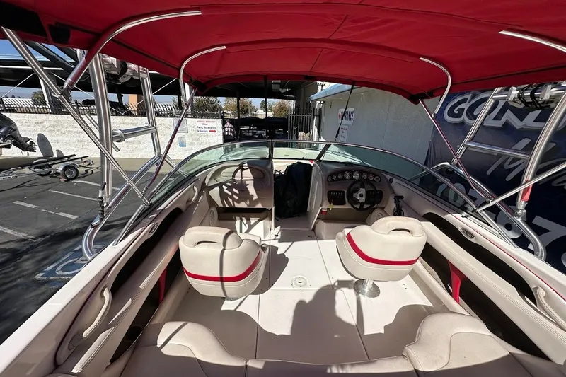 Slide: The Image of Interior view of a 2000 Chaparral 216 SSi boat with red canopy and seating. - 10