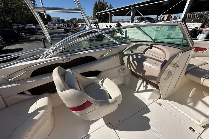 Slide: The Image of Interior of a 2000 Chaparral 216 SSi boat, featuring beige seating and dashboard. - 14