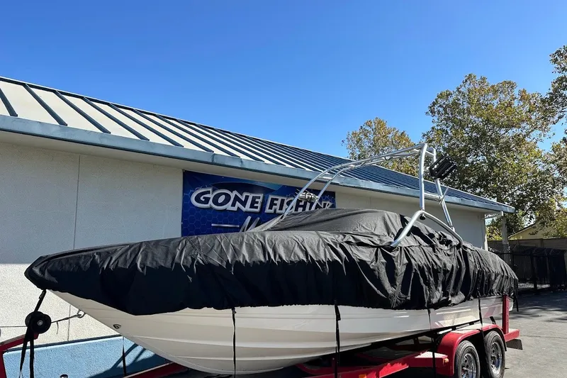 Slide: The Image of Chaparral 216 SSi 2000 boat covered on trailer, parked near building. - 32