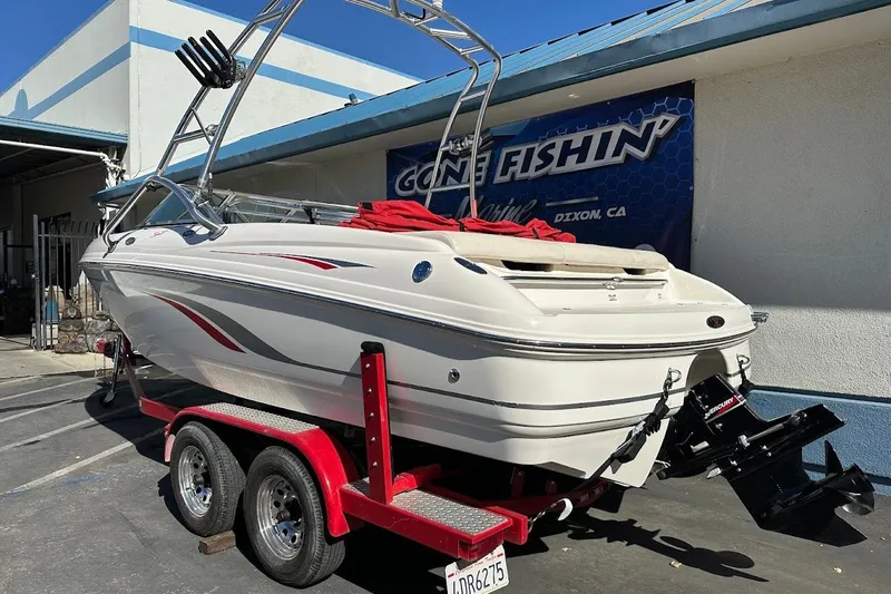 Slide: The Image of 2000 Chaparral 216 SSi boat on red trailer, parked outside a building. - 6