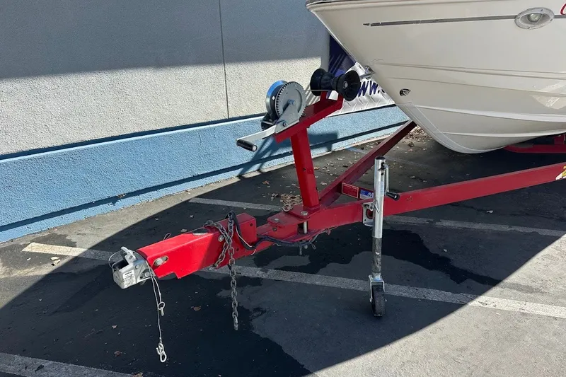 Slide: The Image of Red trailer with Chaparral 216 SSi boat, 2000 model, parked on asphalt. - 3