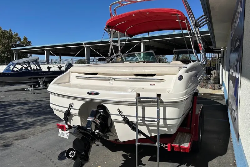Slide: The Image of 2000 Chaparral 216 SSi boat with red canopy on trailer, parked outdoors. - 8