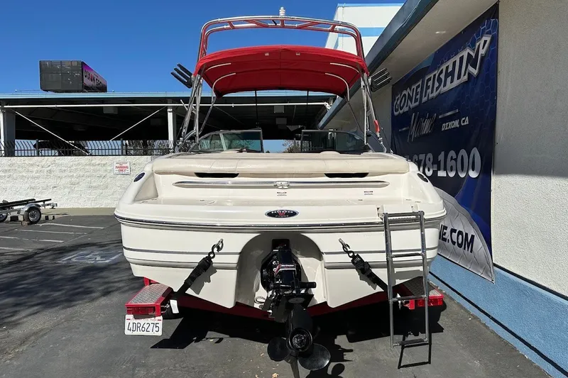 Slide: The Image of 2000 Chaparral 216 SSi boat with red canopy, parked at a marina. - 7