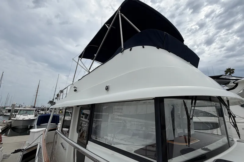 Slide: The Image of 2019 Beneteau Swift Trawler 44 docked at marina under cloudy sky. - 11