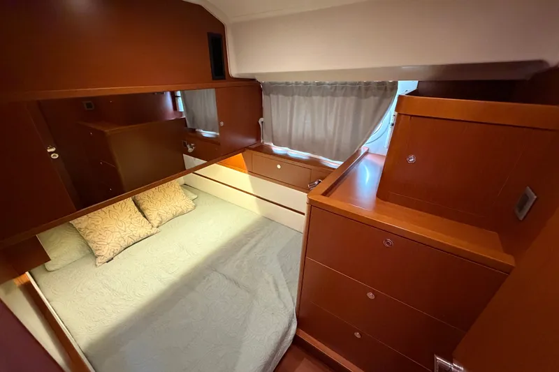 Slide: The Image of Cozy cabin interior of 2019 Beneteau Swift Trawler 44 with wooden furnishings and bed. - 27