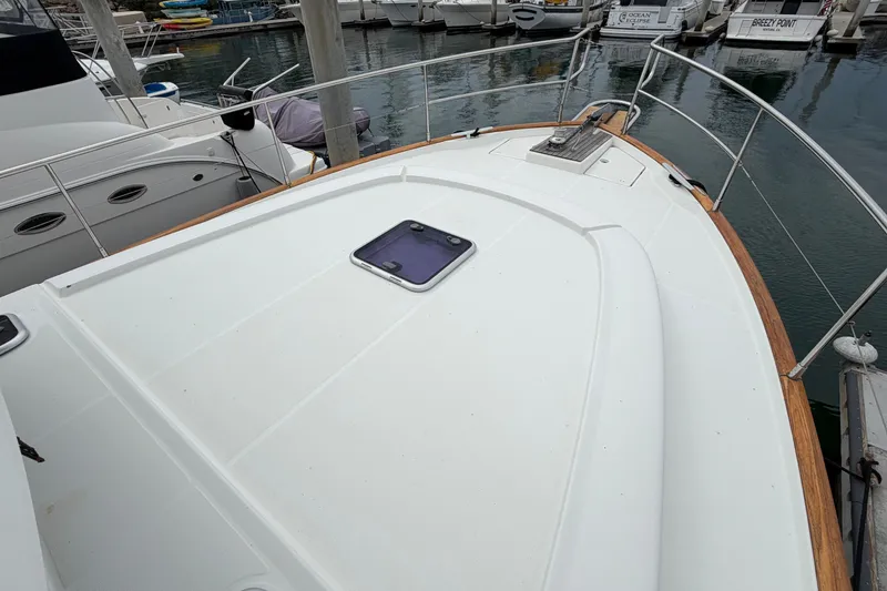 Slide: The Image of 2019 Beneteau Swift Trawler 44 docked, showcasing spacious deck and sleek design. - 13