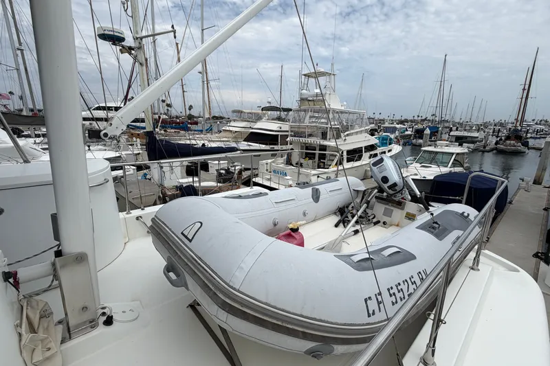 Slide: The Image of 2019 Beneteau Swift Trawler 44 docked with inflatable boat, surrounded by other yachts. - 4