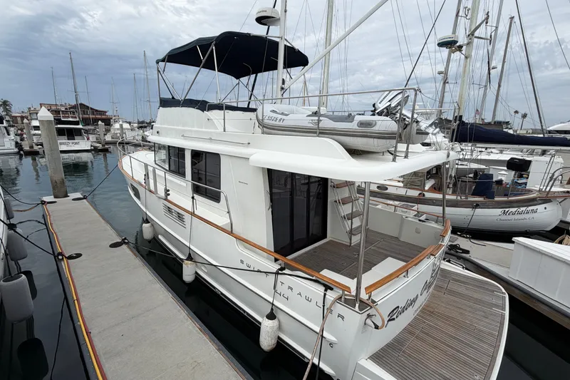 Slide: The Image of 2019 Beneteau Swift Trawler 44 docked at marina, showcasing elegant design and spacious deck. - 3