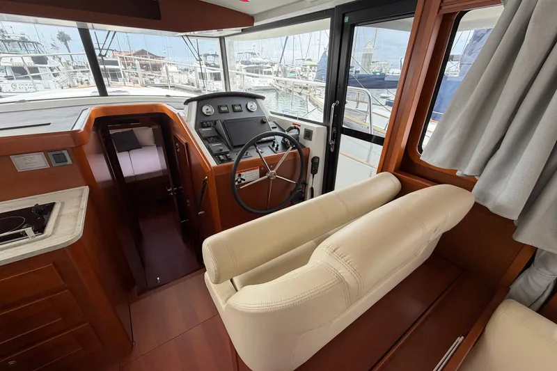 Slide: The Image of Interior of 2019 Beneteau Swift Trawler 44, featuring helm station and seating. - 17