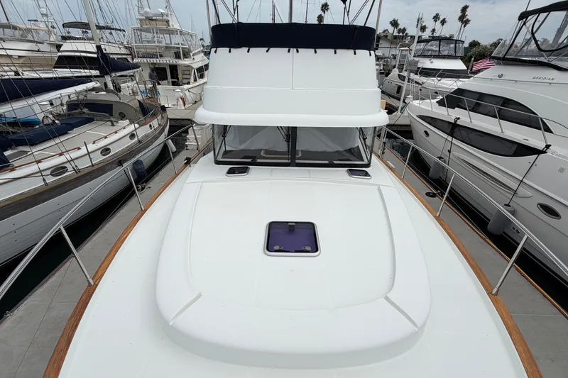 Slide: The Image of 2019 Beneteau Swift Trawler 44 docked among other boats in a marina. - 12