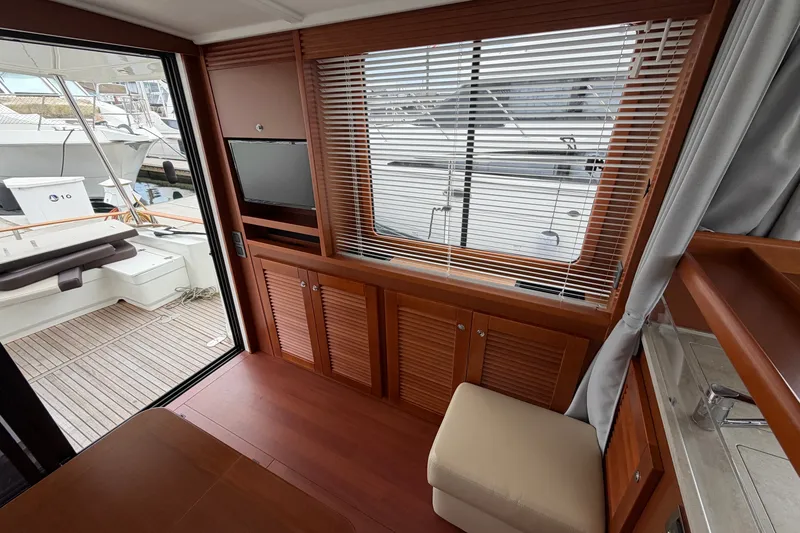 Slide: The Image of Interior of 2019 Beneteau Swift Trawler 44, featuring wood paneling and a view of the deck. - 15