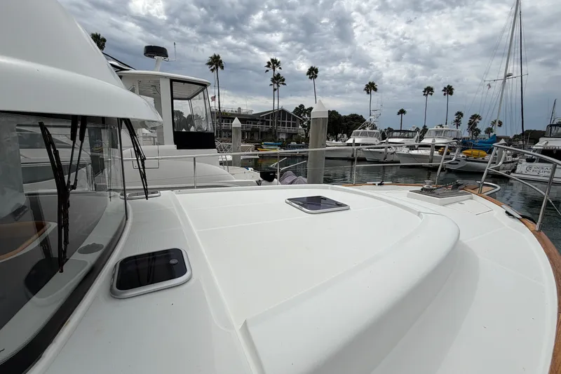 Slide: The Image of 2019 Beneteau Swift Trawler 44 docked at marina, surrounded by palm trees and boats. - 14