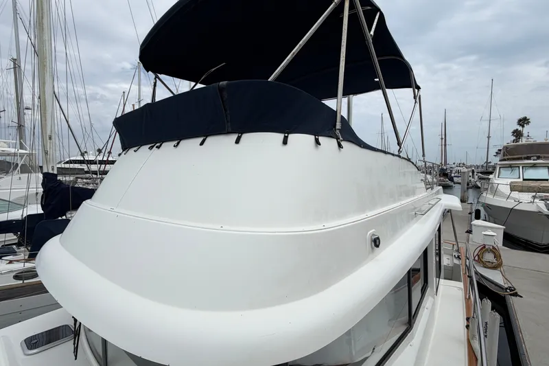 Slide: The Image of 2019 Beneteau Swift Trawler 44 docked at marina, featuring blue canopy and sleek design. - 10