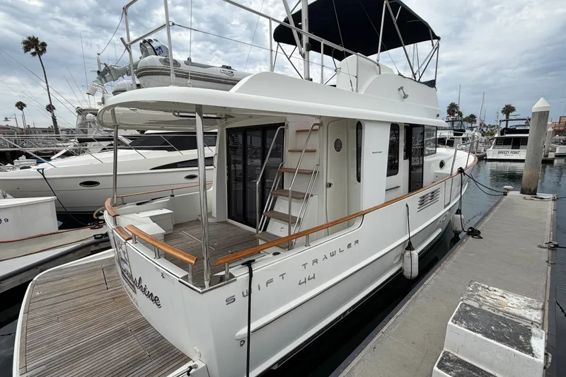 Slide: The Image of 2019 Beneteau Swift Trawler 44 docked at marina, showcasing elegant design and spacious deck. - 6