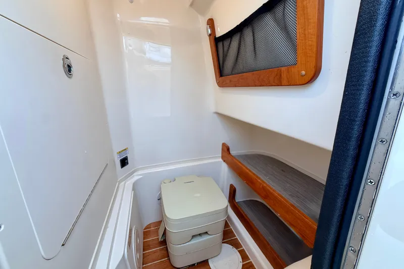 Slide: The Image of 2025 Grady-White Fisherman 257 boat interior with compact toilet and storage shelves. - 20