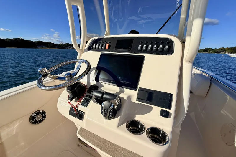 Slide: The Image of 2025 Grady-White Fisherman 257 boat console with steering wheel and navigation controls. - 13