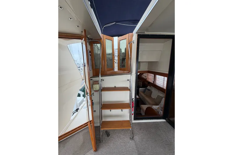 Slide: The Image of 1989 Californian Aft Cabin yacht interior with wooden stairs and cozy seating area. - 15